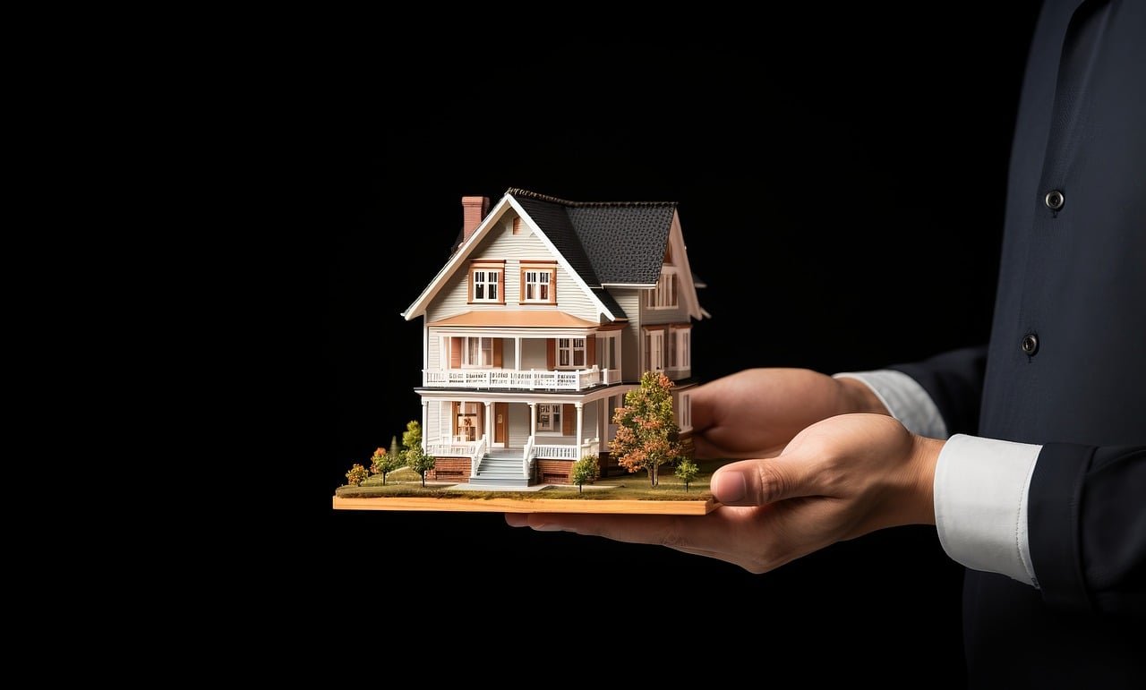 A person holding a model house, symbolizing investment in property through an investment loan.